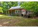 Charming log cabin featuring a side deck and a stone foundation, surrounded by lush greenery at 1615 Hilltop Ct, Woodstock, GA 30188