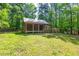 Exterior view of a log cabin style house with a metal awning and surrounded by trees at 1615 Hilltop Ct, Woodstock, GA 30188