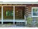 Close-up of the log cabin's front porch, showcasing the wooden door and stone accents at 1615 Hilltop Ct, Woodstock, GA 30188