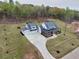 An aerial view of a luxury home with a long driveway and a spacious lawn in a wooded community at 3078 Turning Creek Trl, Dacula, GA 30019