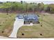 A birds-eye-view of a luxury home with a long driveway and a spacious lawn in a wooded community at 3078 Turning Creek Trl, Dacula, GA 30019