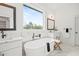 Bright bathroom featuring a soaking tub, large window, and stylish fixtures at 3078 Turning Creek Trl, Dacula, GA 30019