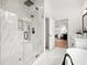 Elegant bathroom with walk-in shower and marble tiling that leads into a Primary bedroom at 3078 Turning Creek Trl, Dacula, GA 30019