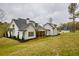 Beautifully landscaped backyard featuring a white two-story house with a separate garage building at 3078 Turning Creek Trl, Dacula, GA 30019