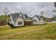 Backyard view of a two-story house boasting white siding, black trim, and lush green lawn at 3078 Turning Creek Trl, Dacula, GA 30019