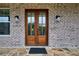 Stunning brick home featuring a stylish, natural wood double front door and stone entryway at 3078 Turning Creek Trl, Dacula, GA 30019
