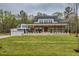 Beautifully designed two-story home featuring a brick-and-white facade, a covered porch, and three-car garage at 3078 Turning Creek Trl, Dacula, GA 30019
