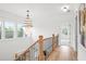 Hallway with decorative chandelier, hardwood floors, and natural light at 3078 Turning Creek Trl, Dacula, GA 30019