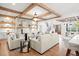 Open-concept living area with hardwood floors, a cozy fireplace, and wood beams at 3078 Turning Creek Trl, Dacula, GA 30019