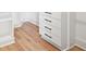 Close-up of a walk-in closet with custom shelving, drawers and hardwood floors at 3078 Turning Creek Trl, Dacula, GA 30019