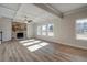 Bright living room featuring coffered ceilings, a stone fireplace, and hardwood floors, with plenty of natural light at 412 Westmarch Cir, Loganville, GA 30052