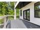 Balcony with gray wood floors, white railing, black door and windows, and white brick walls at 450 Birkdale Dr, Fayetteville, GA 30215