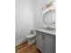 Stylish powder room features a gray vanity, marble countertop, gold fixtures, and hardwood floors at 450 Birkdale Dr, Fayetteville, GA 30215