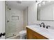 Bathroom with glass shower, marble tile walls, pebble floor, wooden vanity, and black faucet and shower head at 450 Birkdale Dr, Fayetteville, GA 30215