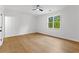 Simple bedroom featuring hardwood floors, a ceiling fan, and a large window overlooking the backyard at 450 Birkdale Dr, Fayetteville, GA 30215