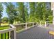 Deck with black metal railings, white posts, gray wood, and a view of the trees and a small lake at 450 Birkdale Dr, Fayetteville, GA 30215