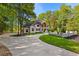 The driveway features lush landscaping, mature trees, and a brick, two-story home at 450 Birkdale Dr, Fayetteville, GA 30215