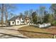 Stately two-story home with a circular driveway, lush landscaping, and a classic white brick facade at 450 Birkdale Dr, Fayetteville, GA 30215