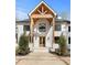 Close-up of the house entrance with a white brick facade and stylish wood accents and double doors at 450 Birkdale Dr, Fayetteville, GA 30215
