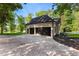 Modern two-car garage with black doors, large driveway, and landscaping at 450 Birkdale Dr, Fayetteville, GA 30215
