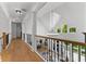 Bright hallway featuring hardwood floors, decorative lighting, and an overlook to the living area below at 450 Birkdale Dr, Fayetteville, GA 30215