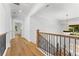 Second floor hallway with wood flooring, iron railing, and chandelier at 450 Birkdale Dr, Fayetteville, GA 30215