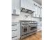 Elegant kitchen features a stainless steel oven and stove with marble countertops and white cabinetry at 450 Birkdale Dr, Fayetteville, GA 30215