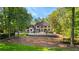A two-story brick home sits on a well manicured lawn, with mature trees in the background at 450 Birkdale Dr, Fayetteville, GA 30215
