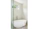 Modern bathroom featuring a white standalone soaking tub and hexagonal tiles on the surrounding walls at 48 25Th St, Atlanta, GA 30309