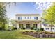 Charming two-story house with a stone retaining wall, white painted brick, and a welcoming front porch at 48 25Th St, Atlanta, GA 30309