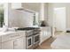 Gourmet kitchen featuring stainless steel appliances, a marble backsplash, and custom cabinetry at 48 25Th St, Atlanta, GA 30309