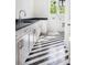 Bright laundry room with black and white patterned floors, modern cabinets, and backyard views at 48 25Th St, Atlanta, GA 30309