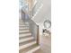 Inviting foyer showcases staircase with light hardwood steps, black metal spindles, and a comfortable bench with pillows at 48 25Th St, Atlanta, GA 30309
