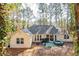This backyard features a hot tub, patio with grill, and lush, wooded surroundings at 6060 Carriage Dr, Cumming, GA 30028