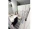 Bathroom featuring a vanity with dark cabinets, marble floors, and a shower with a decorative curtain at 6060 Carriage Dr, Cumming, GA 30028