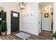Inviting entryway with coat hooks, stylish light fixture, wood-look flooring, and white painted walls at 6060 Carriage Dr, Cumming, GA 30028