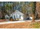 Charming one-story home featuring a white exterior, attached garage, and lush, wooded surroundings at 6060 Carriage Dr, Cumming, GA 30028