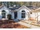 Inviting home exterior featuring a swing, arched windows, dark front door, and well-maintained landscaping at 6060 Carriage Dr, Cumming, GA 30028