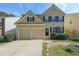 Charming two-story home featuring an attached two-car garage and a well-maintained front lawn at 1050 Dunedin Trl, Woodstock, GA 30188