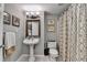 Cozy bathroom features a pedestal sink, decorative mirror, and patterned shower curtain at 6770 Ulster Ct, Alpharetta, GA 30005