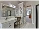 Primary bathroom with a large mirror, white cabinets, granite counters and access to the bedroom at 6770 Ulster Ct, Alpharetta, GA 30005