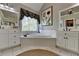 This bathroom showcases a soaking tub, white cabinets, and vanity with dual mirrors at 6770 Ulster Ct, Alpharetta, GA 30005