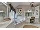 Bathroom boasts dual sinks, a soaking tub under large window, and vanity area with natural lighting at 6770 Ulster Ct, Alpharetta, GA 30005