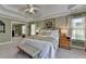 Spacious primary bedroom with tray ceiling, bench seat, and connecting sitting room with view to backyard at 6770 Ulster Ct, Alpharetta, GA 30005