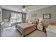This bedroom features neutral colors, a comfortable bed, and a window with natural light at 6770 Ulster Ct, Alpharetta, GA 30005