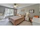 This bedroom features neutral colors, a comfortable bed, and a window with natural light at 6770 Ulster Ct, Alpharetta, GA 30005
