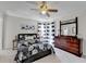 Bright bedroom featuring a patterned comforter, ceiling fan, dresser, and stylish decor, creating a peaceful retreat at 6770 Ulster Ct, Alpharetta, GA 30005
