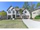 Traditional white brick home featuring a lush front lawn, complemented by a paved driveway and a two-car garage at 6770 Ulster Ct, Alpharetta, GA 30005
