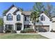 Charming two-story brick home with a well-manicured lawn and a beautiful palm tree at 6770 Ulster Ct, Alpharetta, GA 30005
