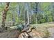 Backyard featuring fire pit with chairs nestled amongst mature trees and natural surroundings at 6770 Ulster Ct, Alpharetta, GA 30005